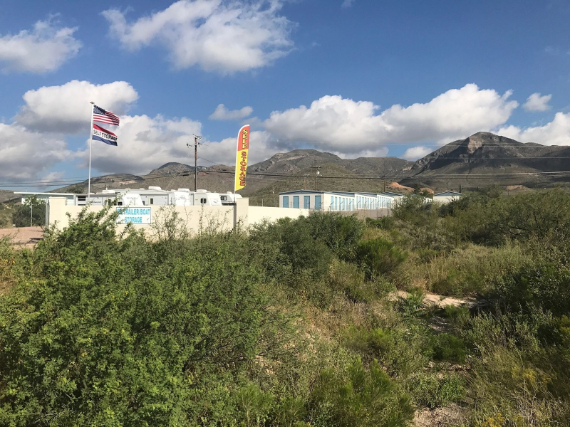 American flag near storage units and mountains